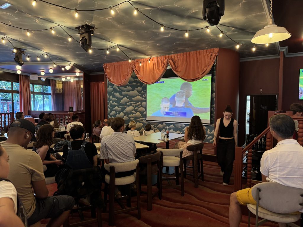 Retransmission d'un match de foot sur un écran géant dans le restaurant-bistrot le Grand-bain.