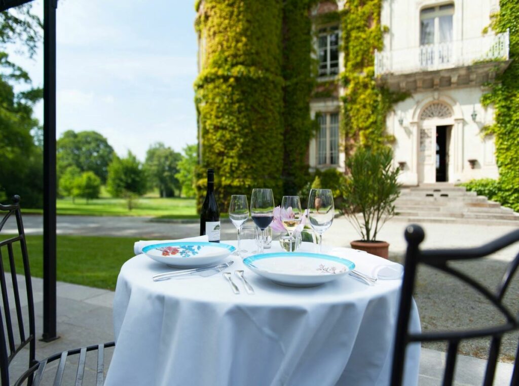 Table de deux couverts sur la terrasse en face de l'entrée du château