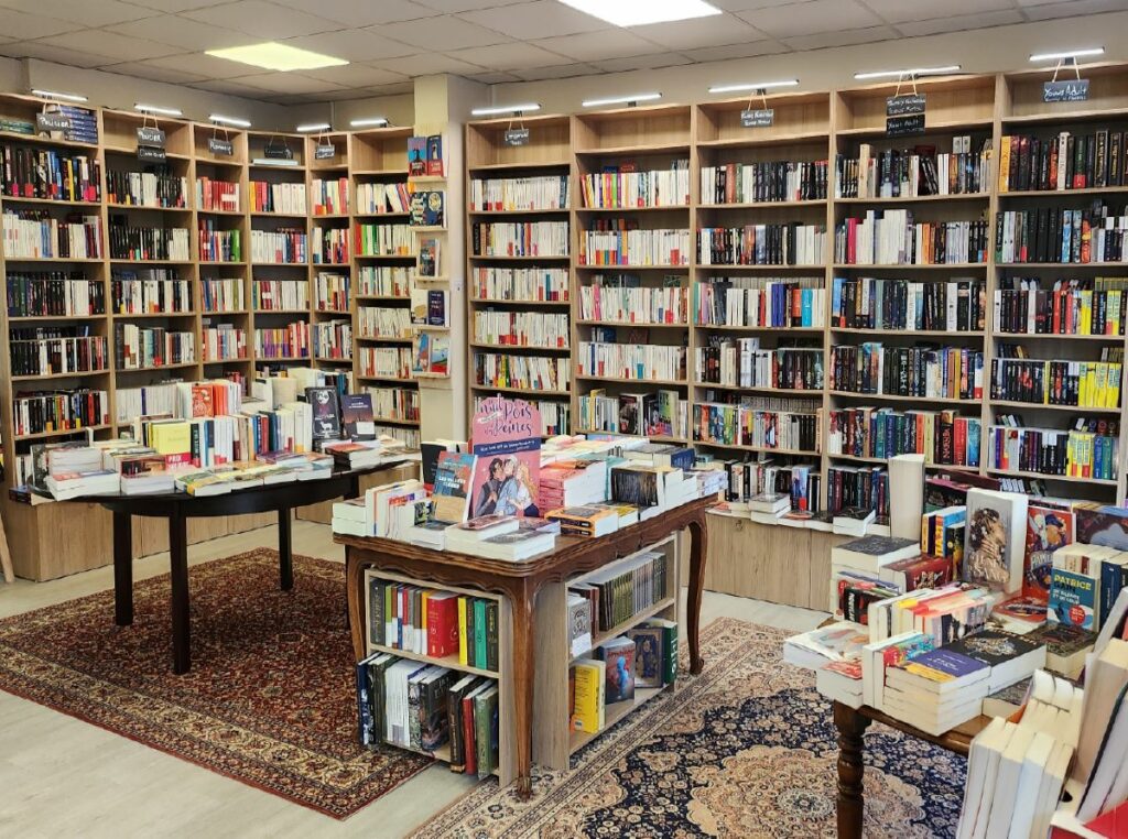 Etagères-bibliothèques et tables remplies de livres dans la librairie