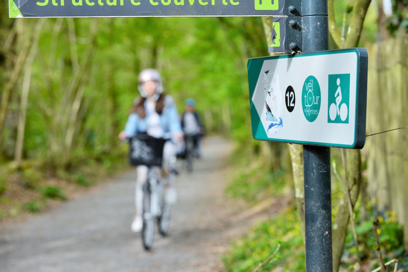 cycliste et panneau d'indication dans le parc des Gayeulles