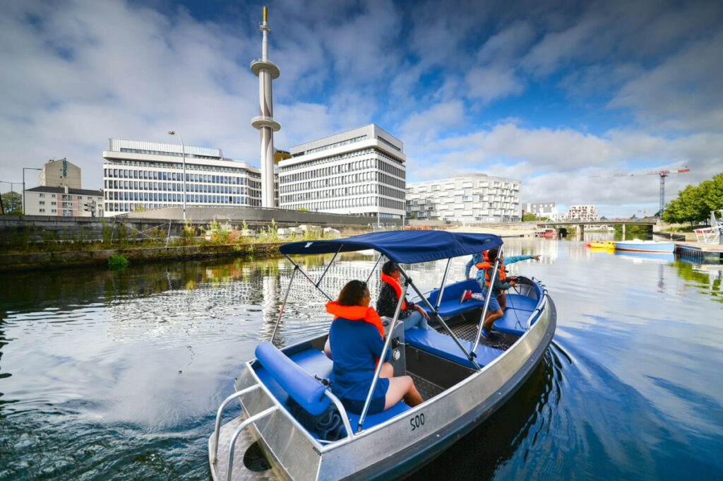 Bateau sans permis navigant sur la Vilaine dans le centre-ville de Rennes.