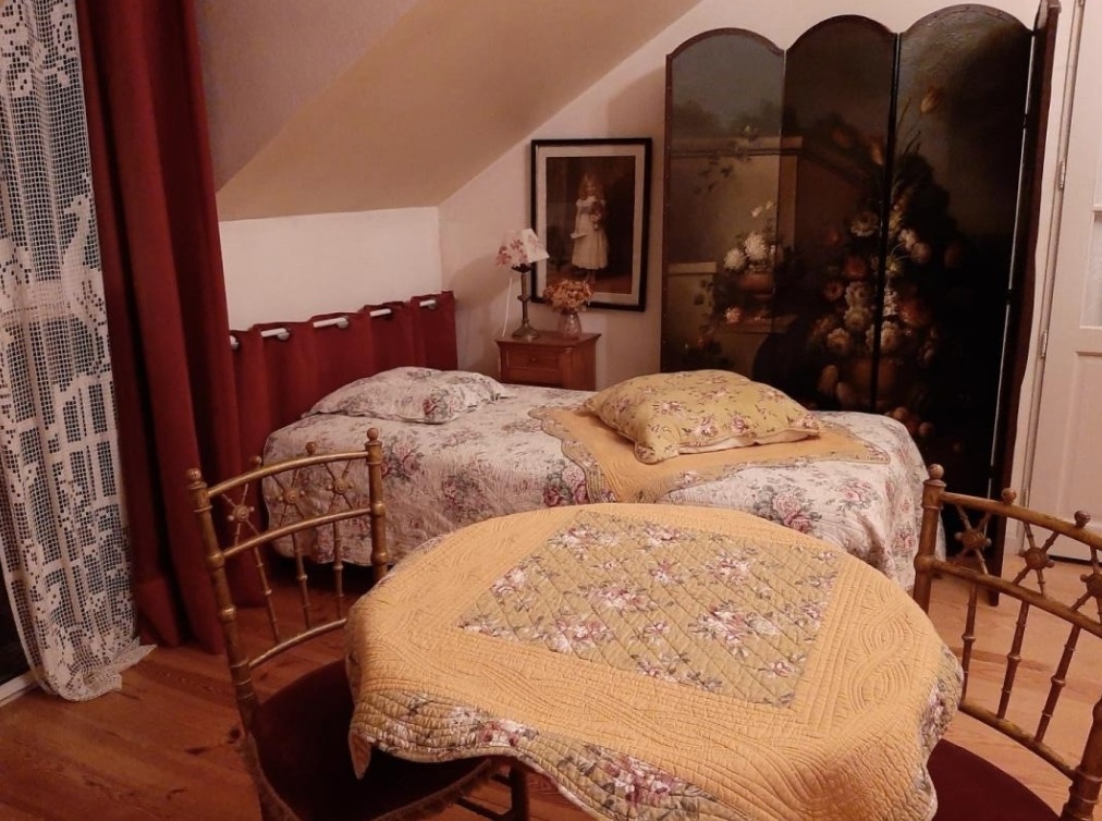Chambre avec lit simple, table et deux chaises