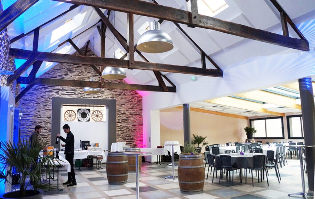 Salle des fêtes du logis avec tables, chaises et buffet