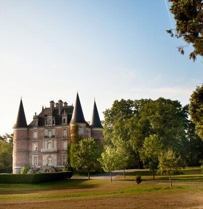 Vue éloignée du château au milieu de son parc