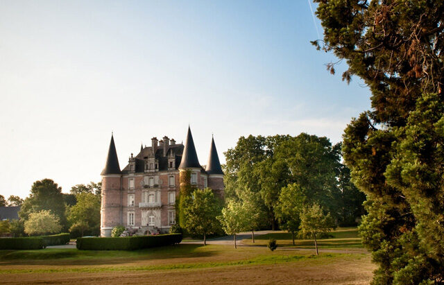 Vue éloignée du château au milieu de son parc