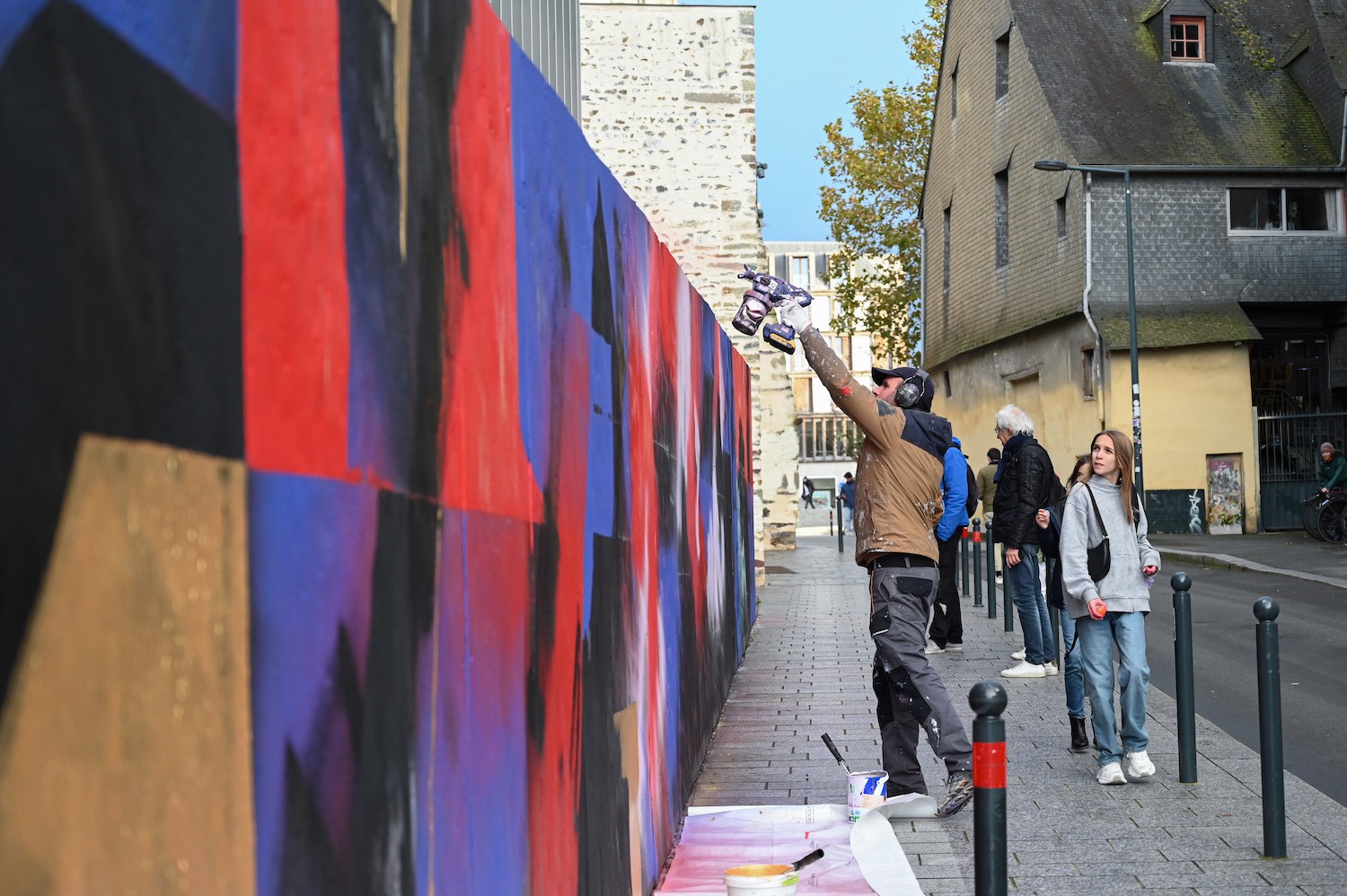 Yann l'Outsider en train de réaliser une fresque de street art de 60 mètres de long