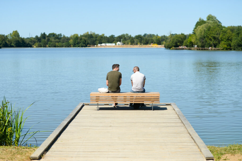 Deux personnes assises sur un ponton face aux étangs d'Apigné
