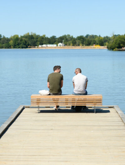 Deux personnes assises sur un ponton face aux étangs d'Apigné