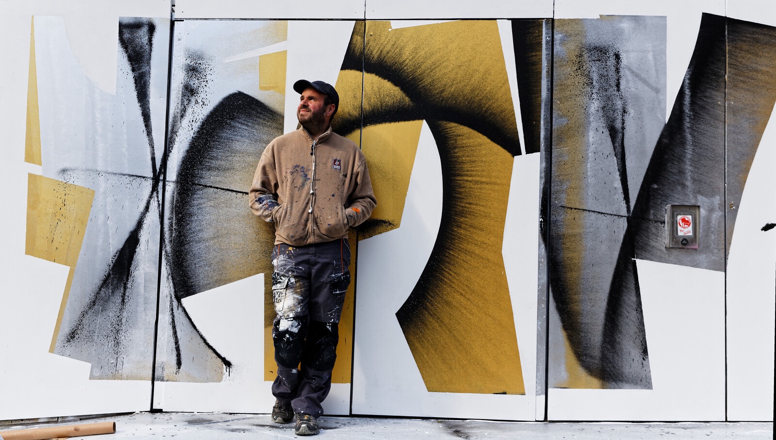 Le street-artiste l'Outsider pose devant une de ses fresques à Rennes