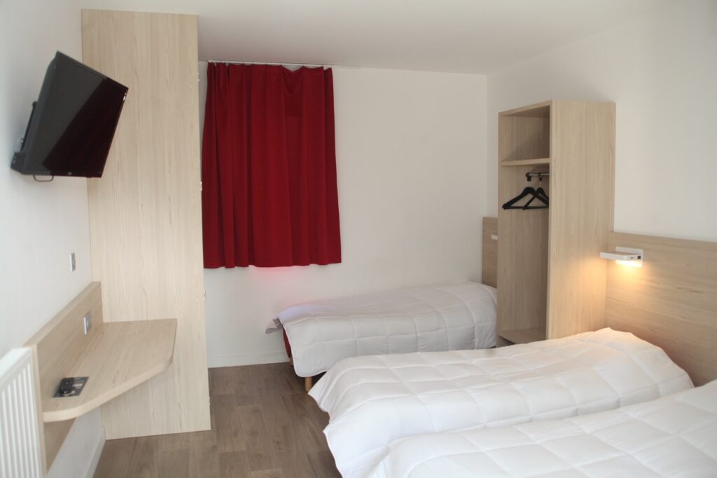 Chambre avec trois lits