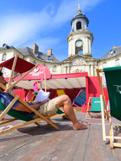Personne installée sur un transat face à l'Hôtel de Ville