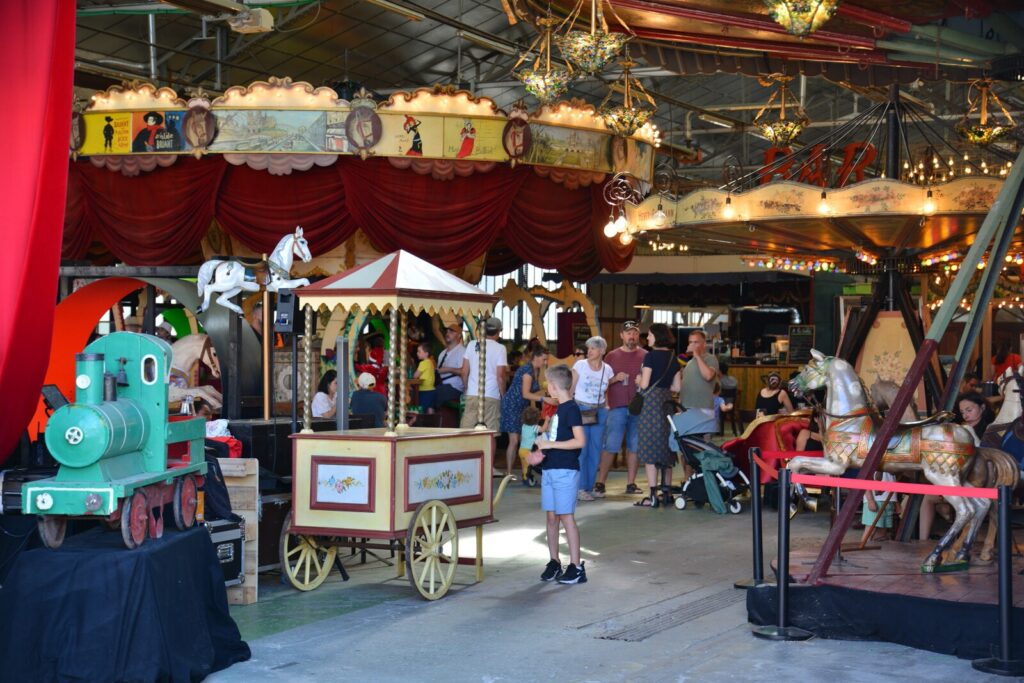 Intérieur du Grand Huit, lieu de vie dédié aux arts forains avec une guinguette couverte.