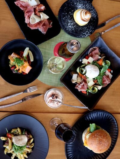 Assortiment de plats avec burger, pâtes, poisson, dessert, charcuterie et fromage