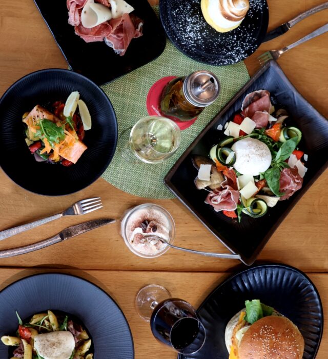 Assortiment de plats avec burger, pâtes, poisson, dessert, charcuterie et fromage