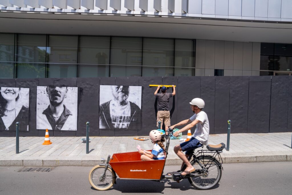 L'artiste rennais Alexandre Bouchon pendant la réalisation de sa fresque de portraits Polaroïd sur le mur de la rue d'échange.