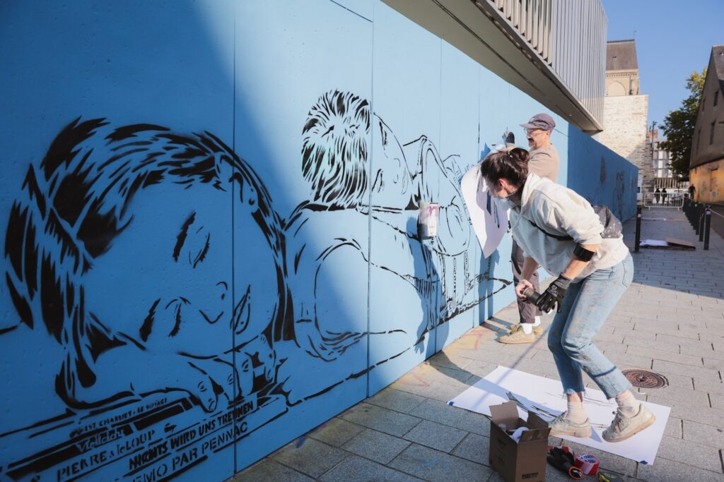 Le duo d'artiste Jana & JS pendant la réalisation de leur fresque en octobre 2025
