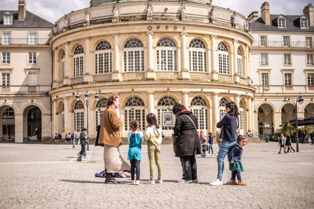 Adultes et enfant devant l'opéra de Rennes.