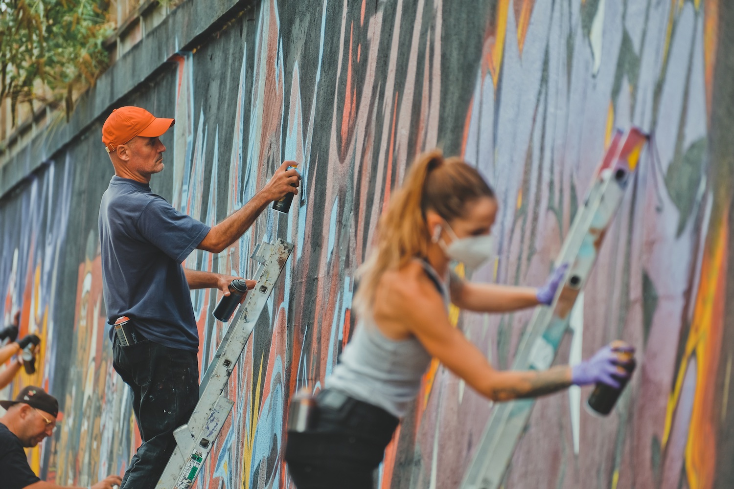 Artistes urbains en train de décorer le mur du boulevard du Colombier
