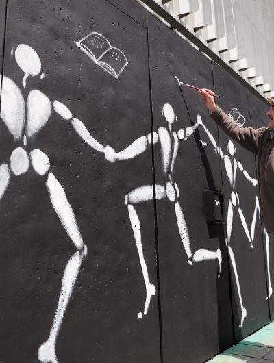 L'artiste Jérome Mesnager réalise une fresque avec ses célèbres bonhommes blancs sur la mur du Couvent des Jacobins
