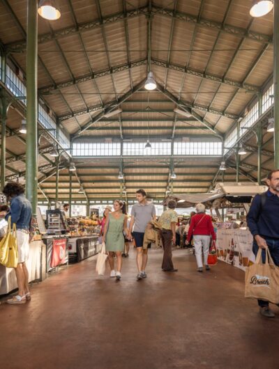 Un couple marche dans la Halle Martenot pendant le marché des Lices