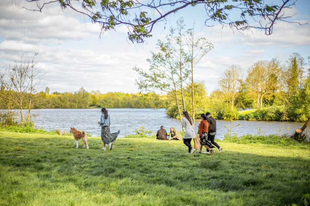 Une famille se promène avec un chien au bords des étangs d'Apigné
