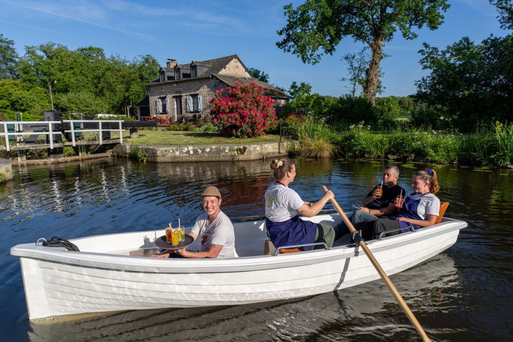L'équipe du bistrot Grugedaine à bord d'une barque devant la maison éclusière à Chevaigné.