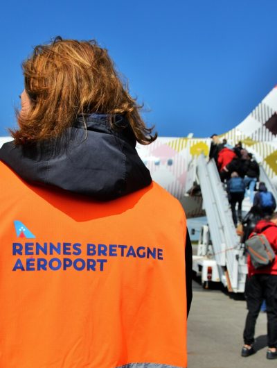 Des passagers embarquent dans un avion sous les yeux d'une personnel au sol