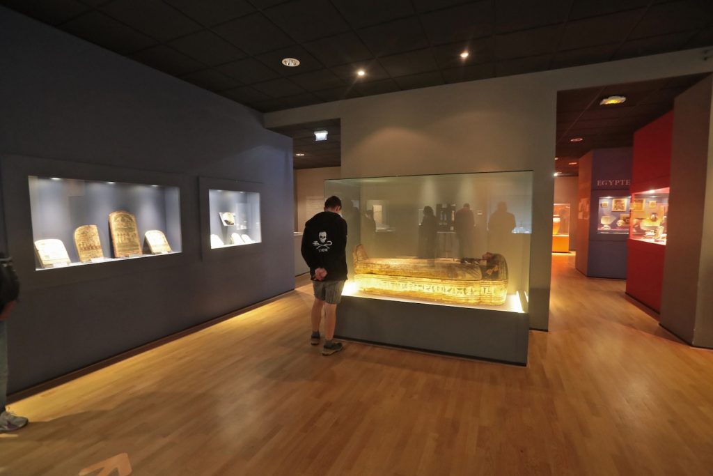 Visiteur devant un sarcophage doré dans la salle égyptienne du Musée des beaux-arts