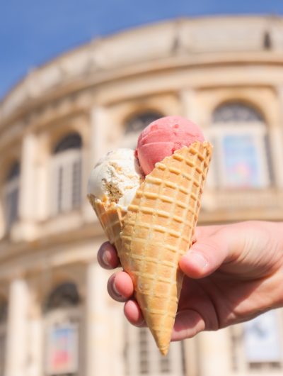 Gros plan sur une glace sous le soleil rennais avec en arrière-plan la façade de l'opéra