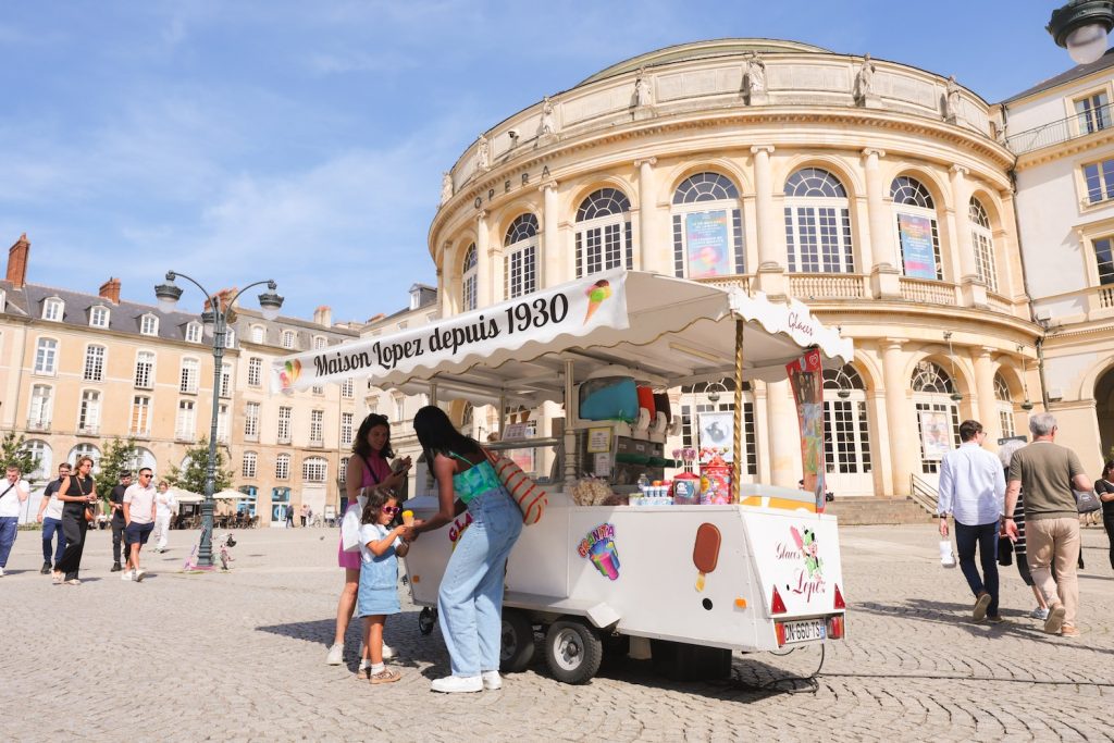 Une famille commande des glaces place de la mairie dans le foodtruck Maison Lopez