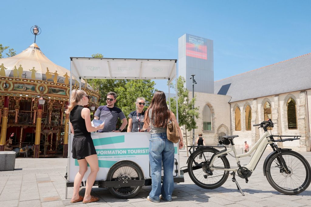 Les conseillers en séjour du point d'information touristique mobile sur la place Sainte-Anne répondent aux questions des visiteurs