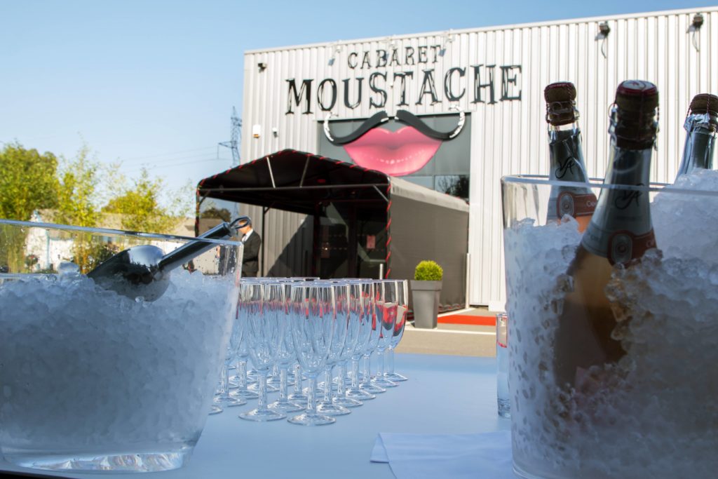 Table nappée dressée pour un cocktail devant l'entrée du Cabaret Moustache